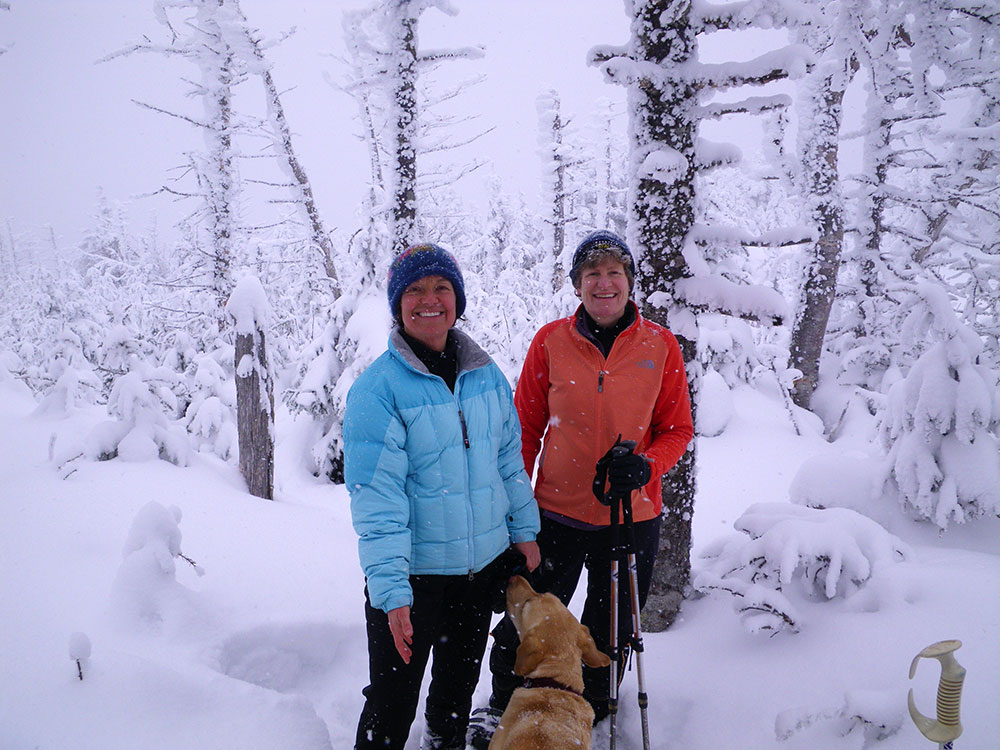 Pat, Nancy and Dejah two hikers and a lab on the trail in winter