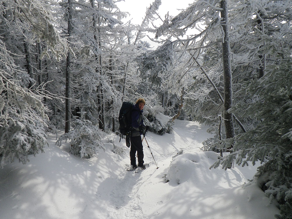 hiker heading down the trail after reaching the summit of Cannon Mtn