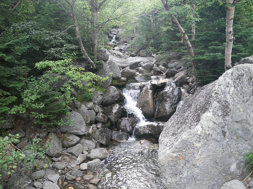 waterfall tumbling over boulders in mid-summer