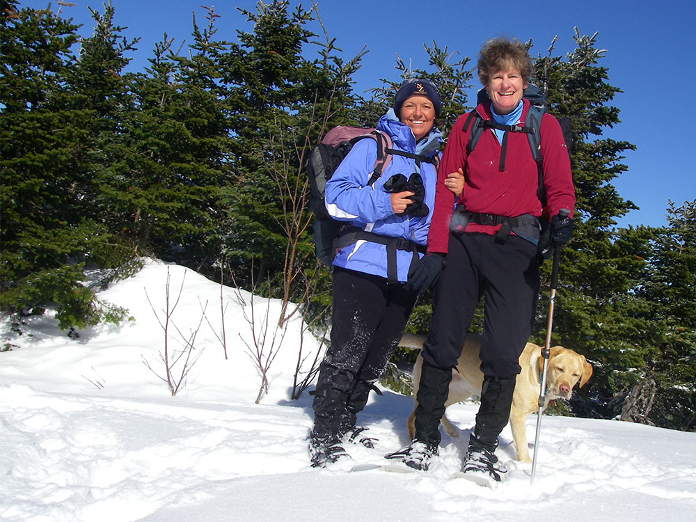 two hikers and a lab on the summit of Mt. Tom