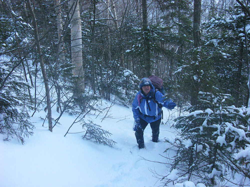 hiker climbing in deep snow