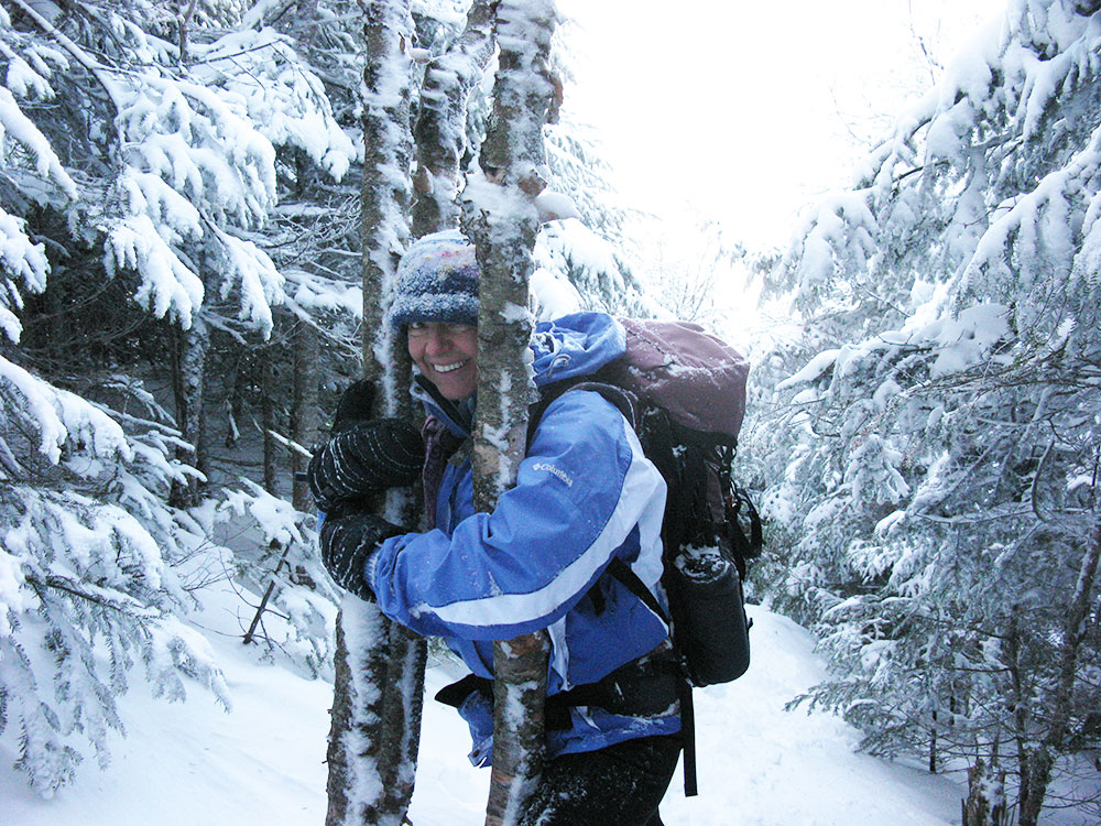 hiker holding onto a tree and laughing