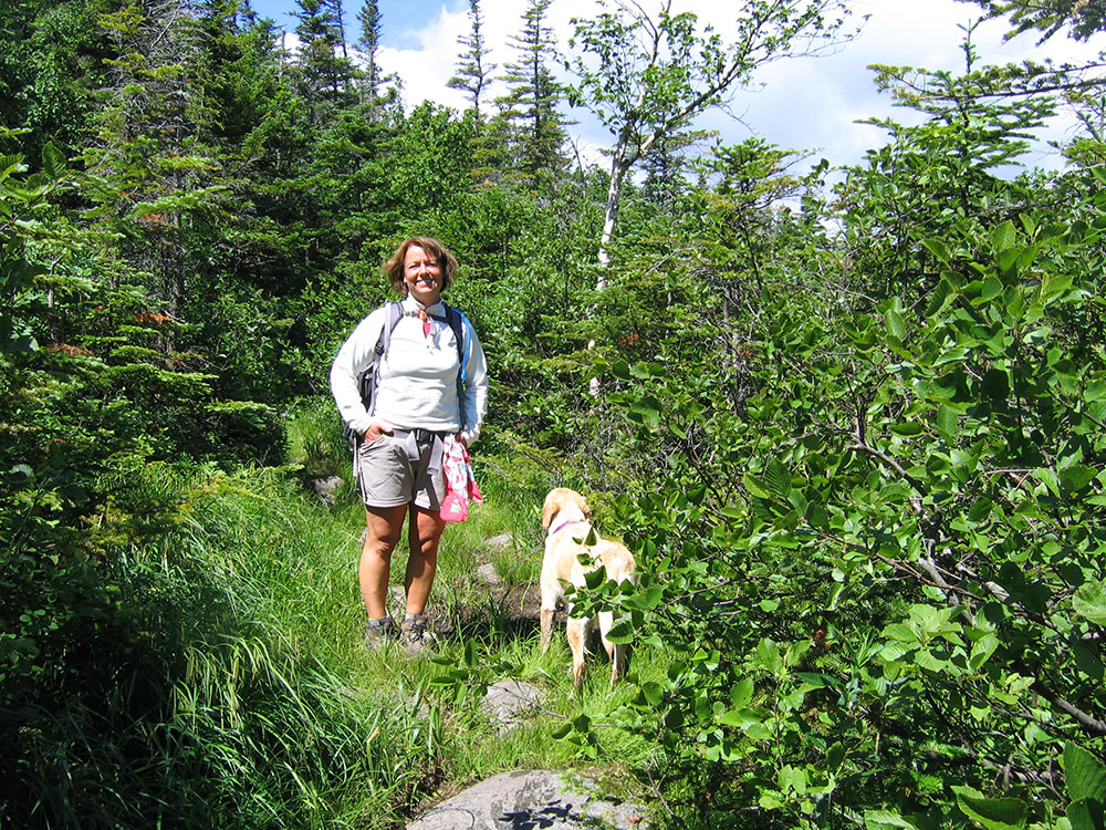 woman hiker and dog on the trail