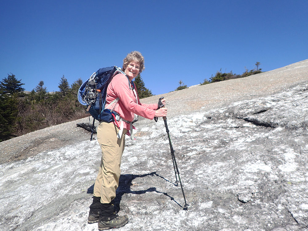 hiker climbing rock slab