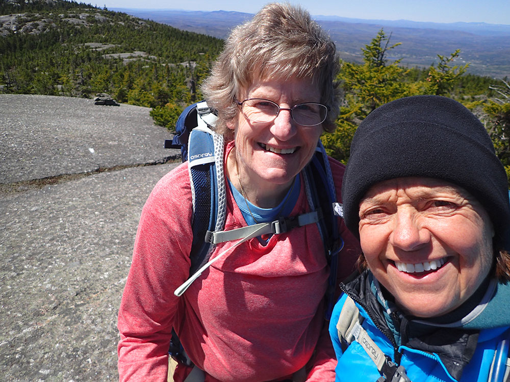 two hikers taking a selfie on the summit of Mt Orange