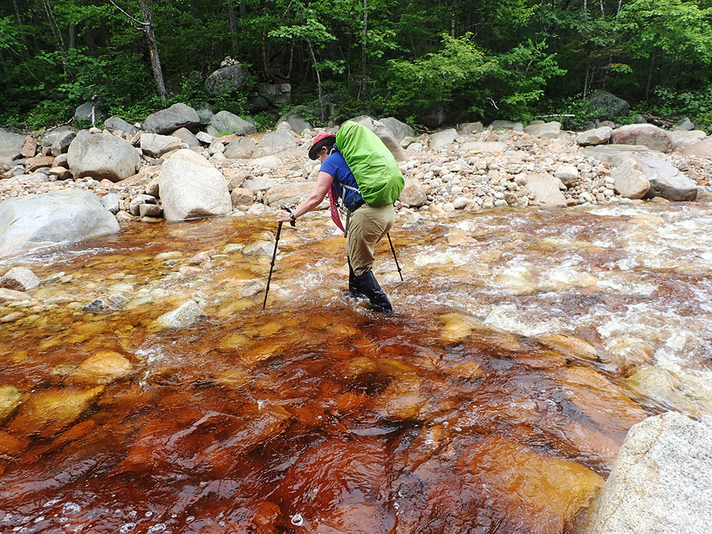 Pat hiker crossing a wide stream