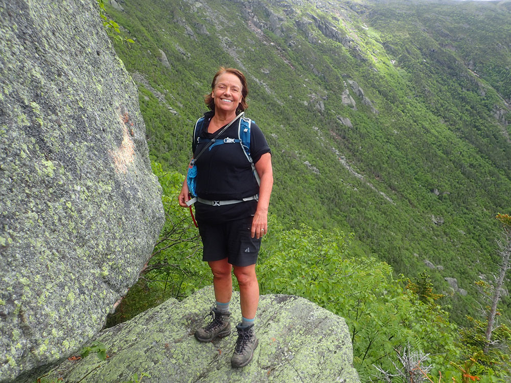 hiker standing on a rock with a headwall behind her