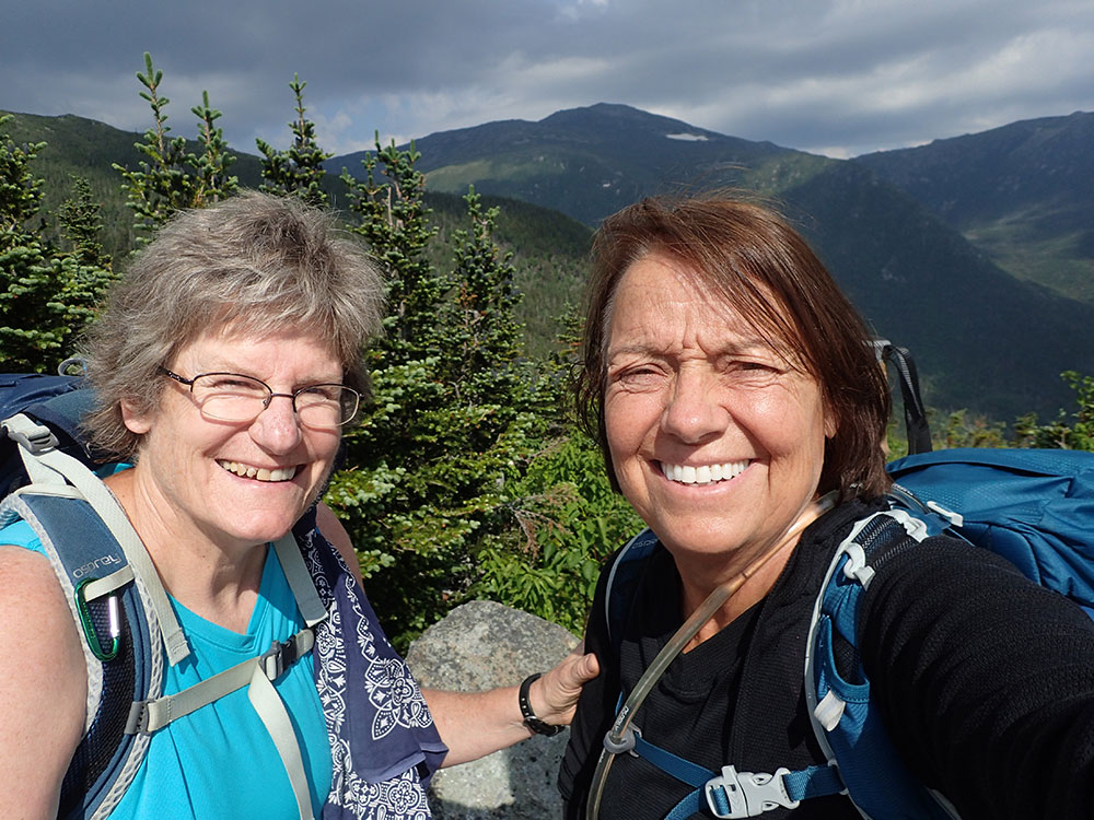 two hikers taking a selfie at the beginning of the Chandler Brook Trail