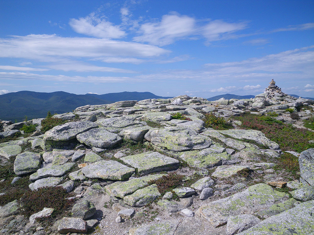 view of rocky ledges on a sunny day, mountains in the distance