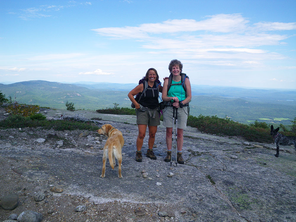 hikers posing at the top of a ridge above tree line