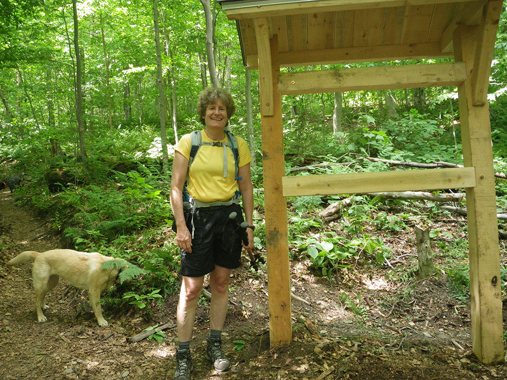 hiker at the trailhead in summer with yellow lab