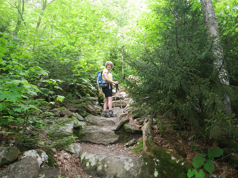 hiker on rocky stairs stepping up the trail