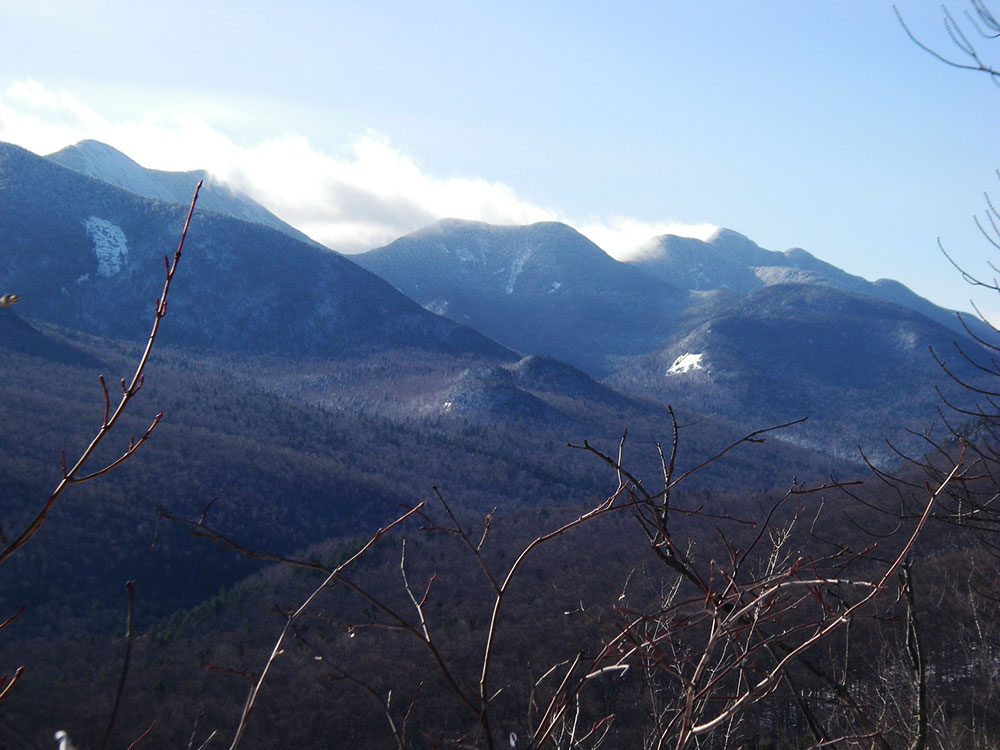 wiind whipping clouds off higher peaks in teh distance