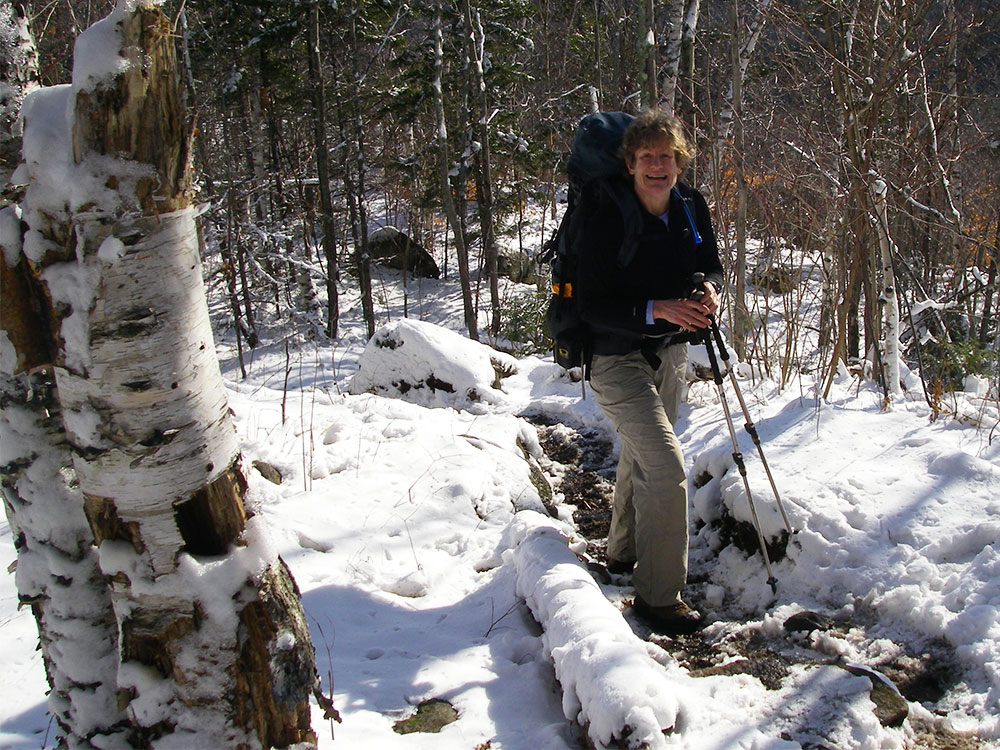 hiker climbing snowy trail
