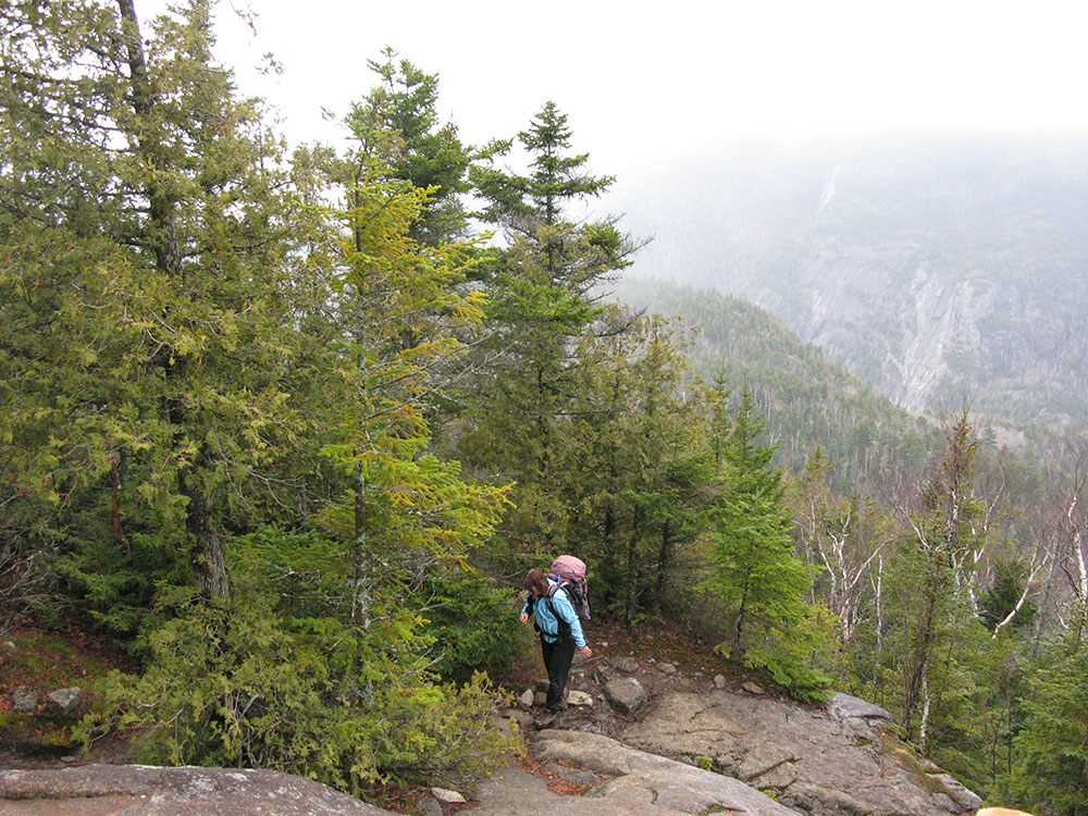 hiker climbing the trail on rock slab
