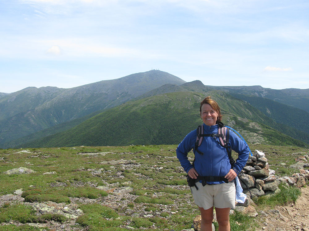 Nancy hiker posing with Mt Washington in the distance