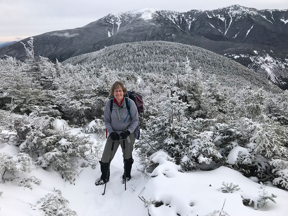 hiker climbing on snowy trail