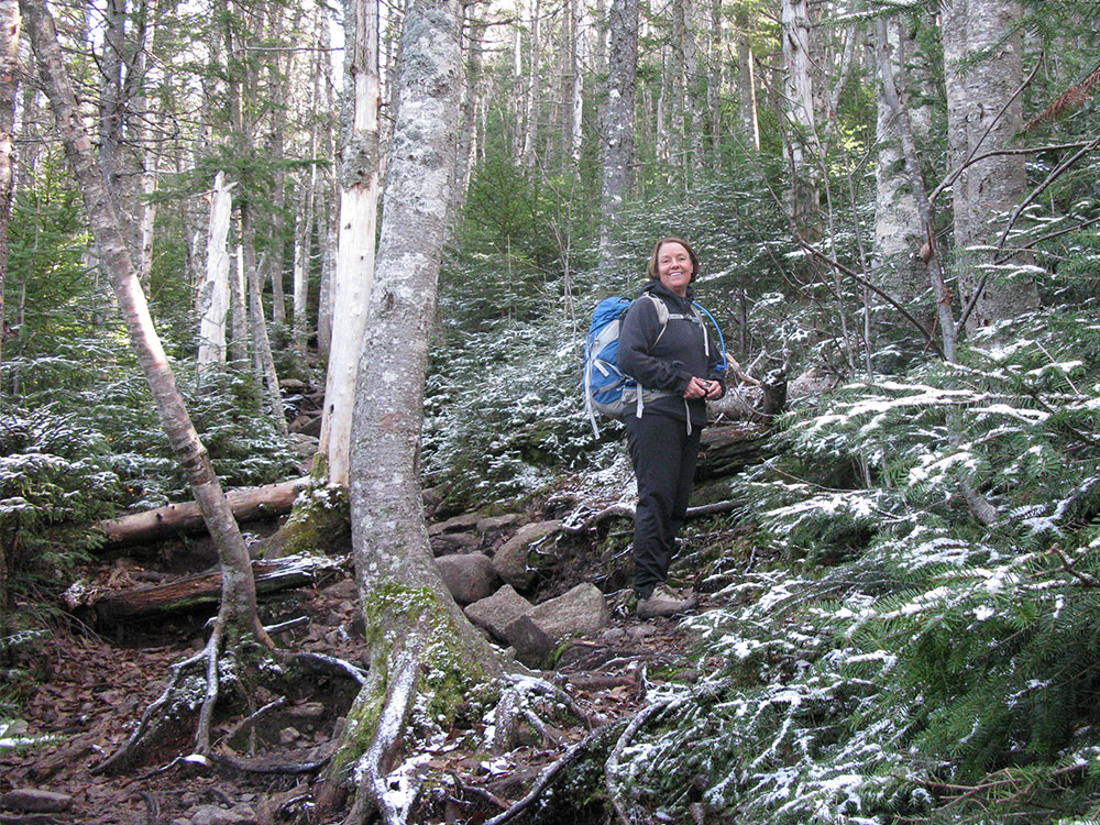 hiker climbing trail with snow