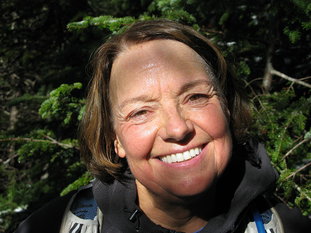 hiker lookingh up and smiling at photographer