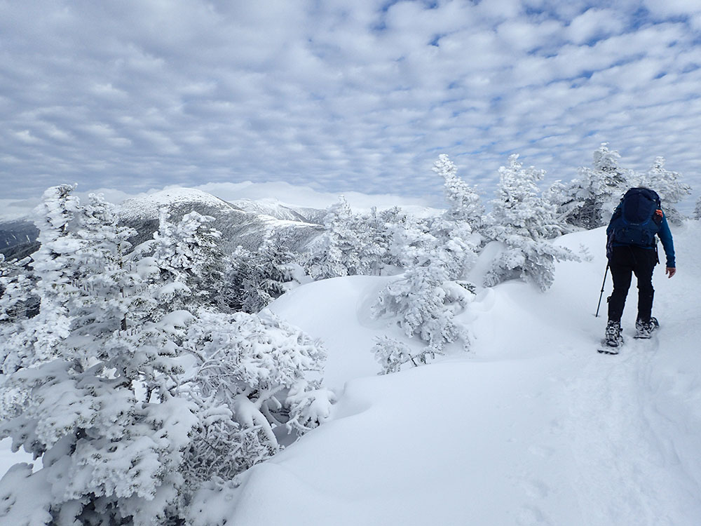 hiker climbing trail to the summit of mountains