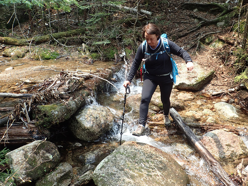hiker crossing a stream