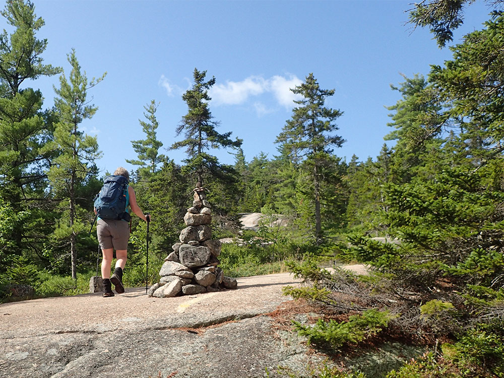 Pat hiker on trailo above treeline with cairns marking the way