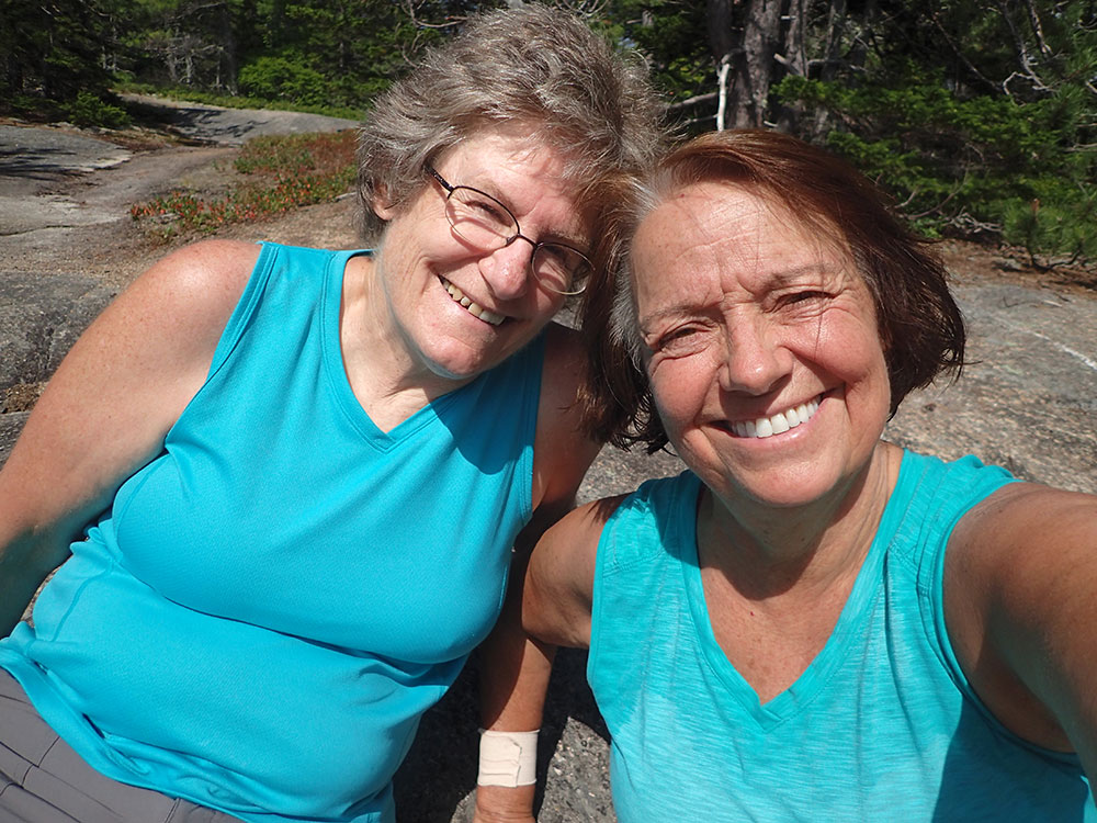 Pata dn Nancy two hikers taking a selfgie sitting on rock slabs above tree line