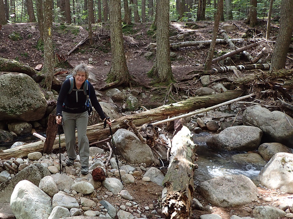 Pat hiker crossing a stream