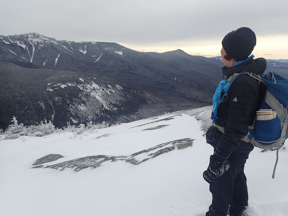 hiker gazing off toward mountains in the distance